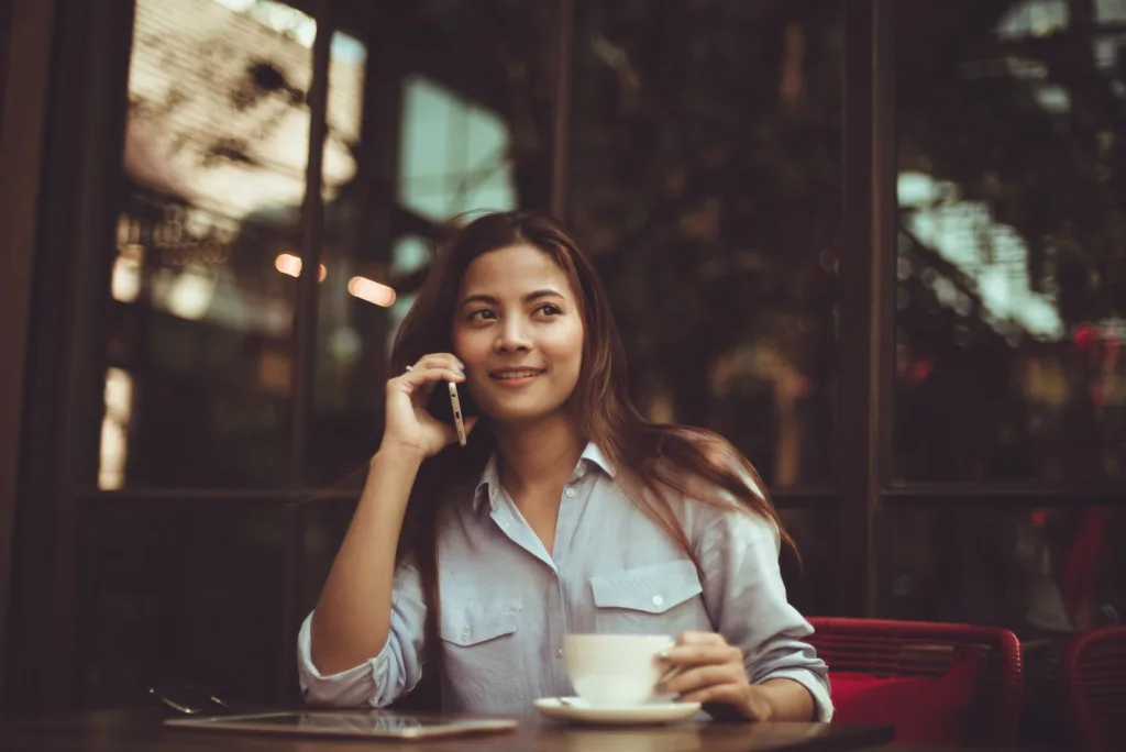 Portrait of Young Woman Using Mobile Phone in Cafe Financial stress Money matters Communication and trust