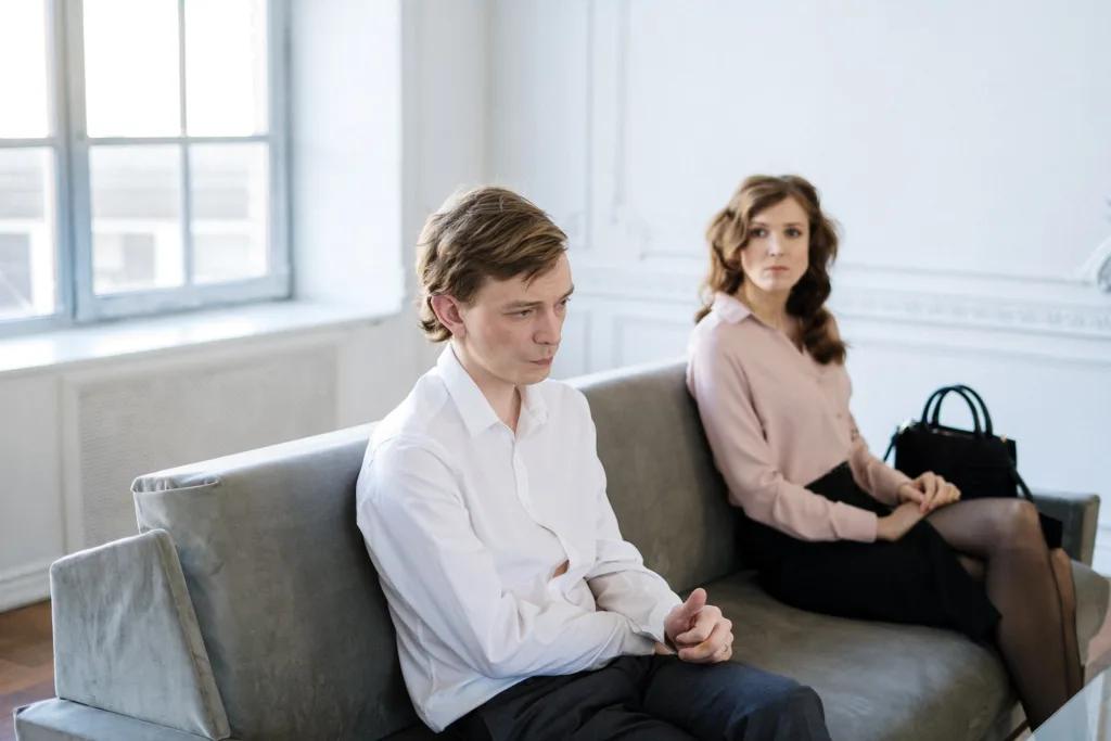 Man in White Suit Sitting Beside Woman in Black Dress. common marriage reconciliation mistakes to avoid after infidelity.