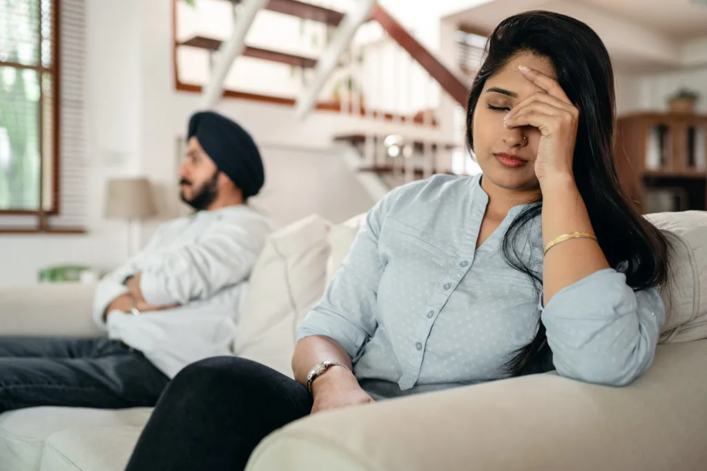 Upset young Indian couple after conflict. Wondering whether to stay or walk away after an affair or infidelity in marriage?