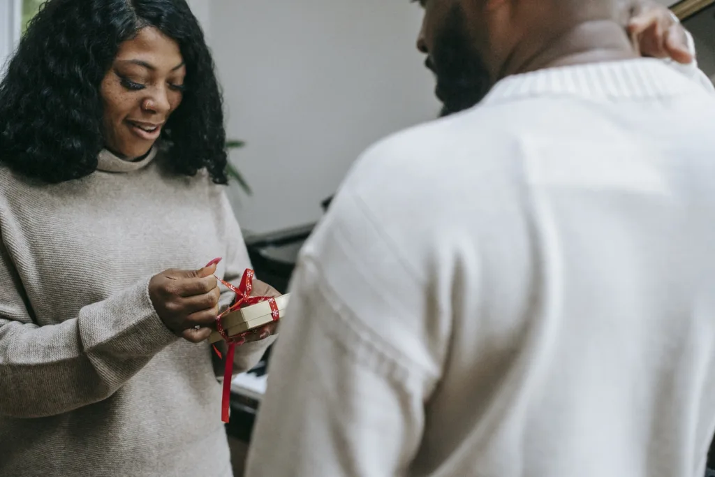 Black couple in sweaters congratulating each other on Christmas. Defining love and obsession. powerful emotions romantic relationships 