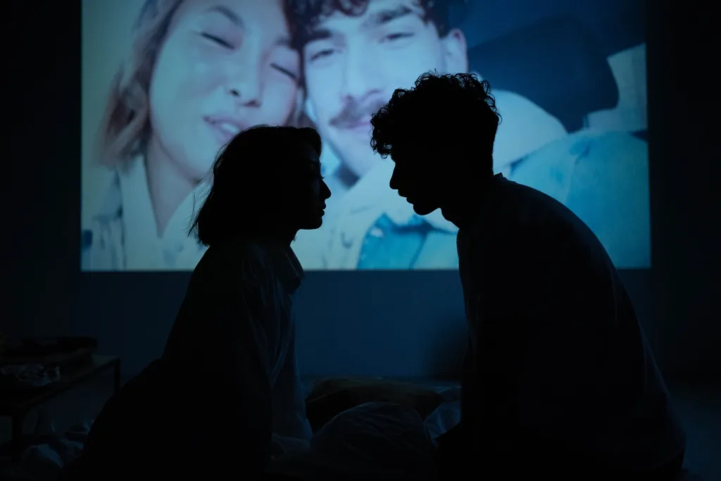 Couple Sitting Together Near a Projector Screen as a way to overcoming infidelity.