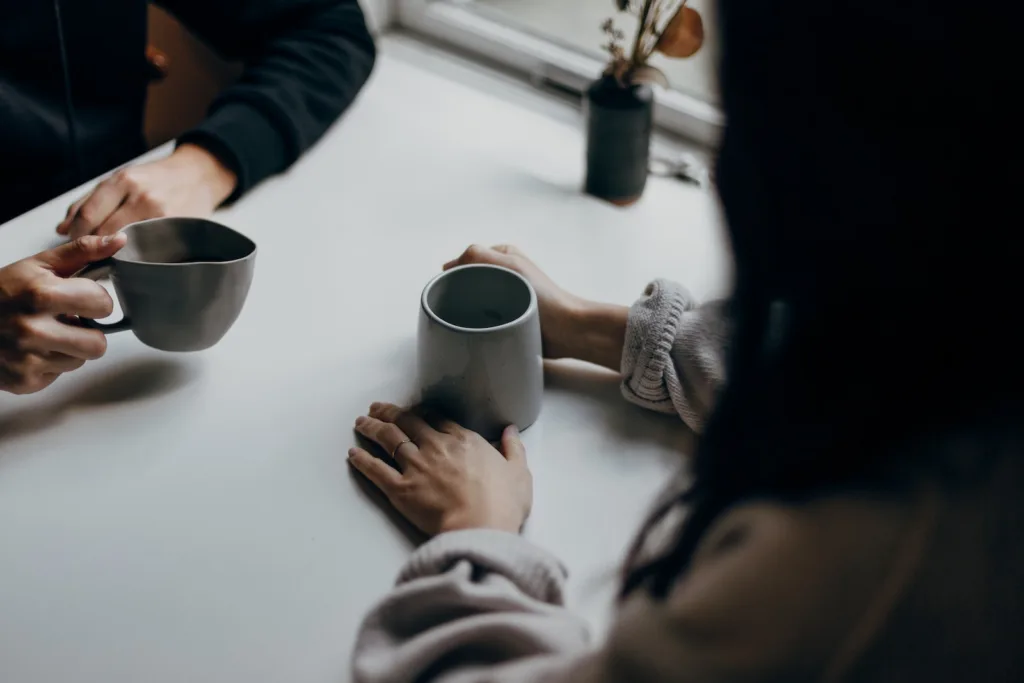 woman in black long sleeve shirt holding black ceramic mug. Decoding first date hugs and meaningful connections.