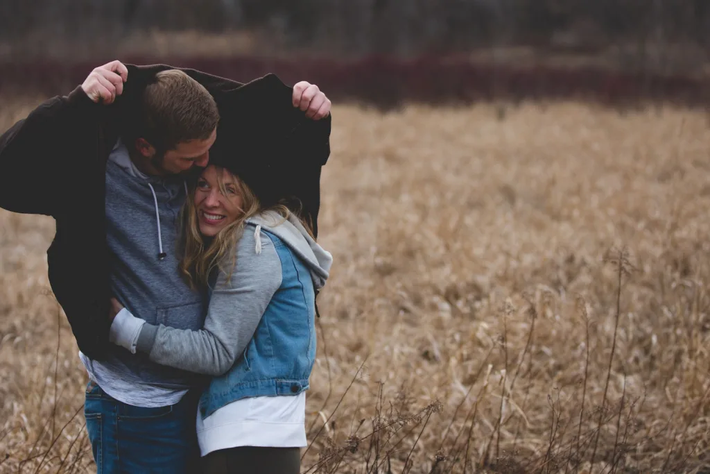 Man and Woman Hugging on Brown Field. Making sacrifices are signs he wants to marry you