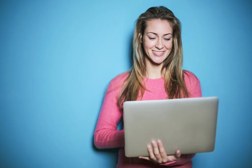 Woman in Pink Long Sleeve Shirt Holding Silver Laptop Computer - Your long-distance relationship, regular communication, spice up romance. 