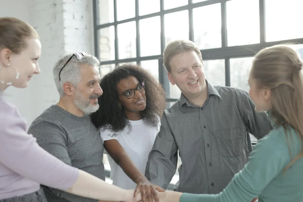 Cheerful diverse colleagues joining hands after coming to agreement. Releasing someone uninterested, cut off communication.