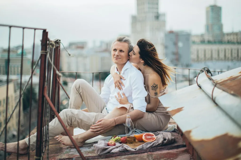 Happy couple having picnic on rooftop. Overcoming obstacles, passion in a marriage