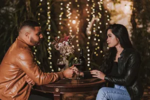 Couple Sitting at a Table and Drinking Red Wine