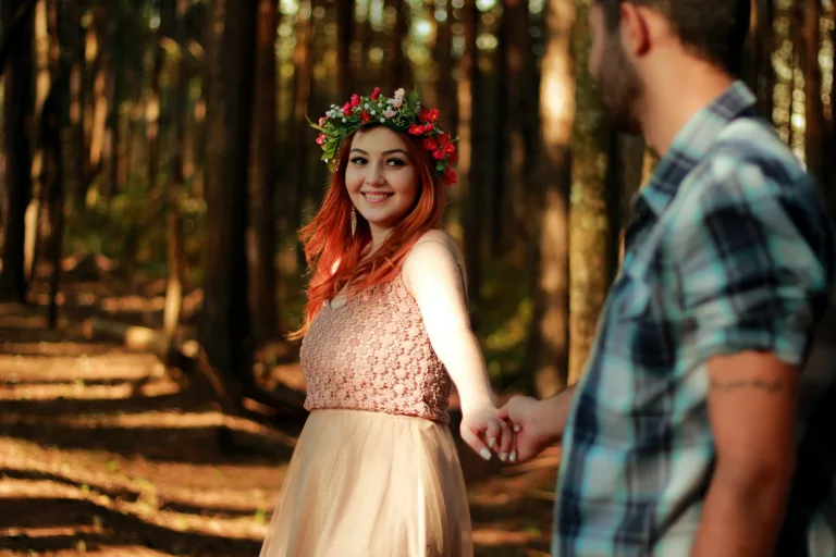 couple holding hands while standing near tree barks. They depict true love in a romantic relationship.