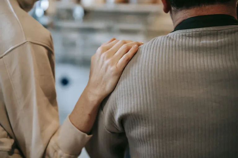 Unrecognizable woman touching shoulder of man at home. Insensitive spouse Empathy Gap