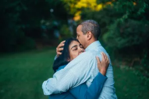 man hugging woman near trees. Forgiveness after emotional infidelity