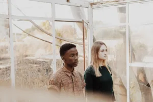 man in brown shirt beside woman in black shirt. Multicultural relationship