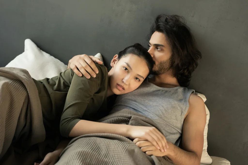 Woman in Green Top Lying on a Man's Chest in Bed. Strengthening passion, embracing vulnerability, role of communication, power exchange in relationships