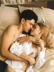 Brunette Man and Blonde Woman Hugging in Bed - Relationship