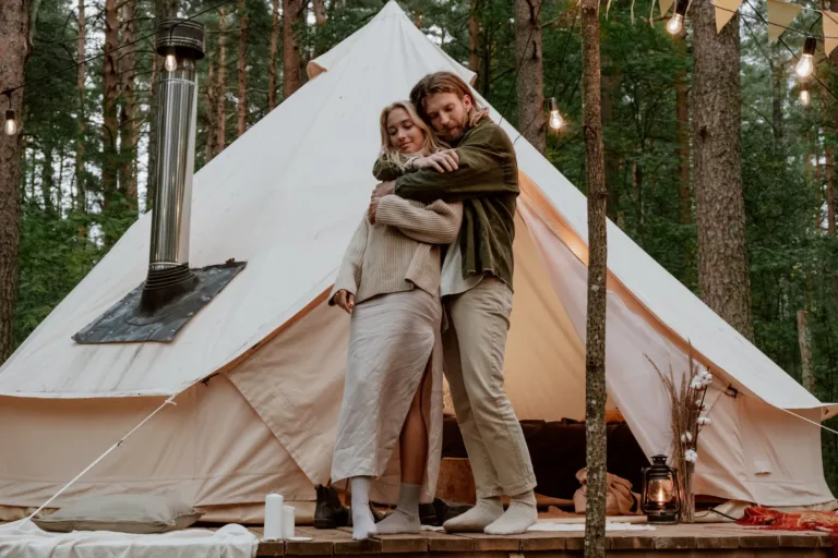 Photo of a Couple Hugging Near a White Tent - Emotional Need, Harmonious relationship