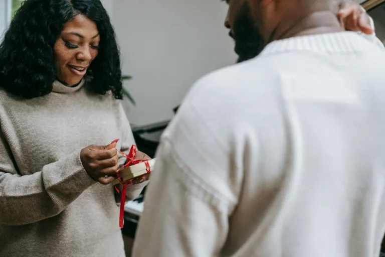 Black couple in sweaters congratulating each other on Christmas. Simple gestures, Gratitude to your partner.